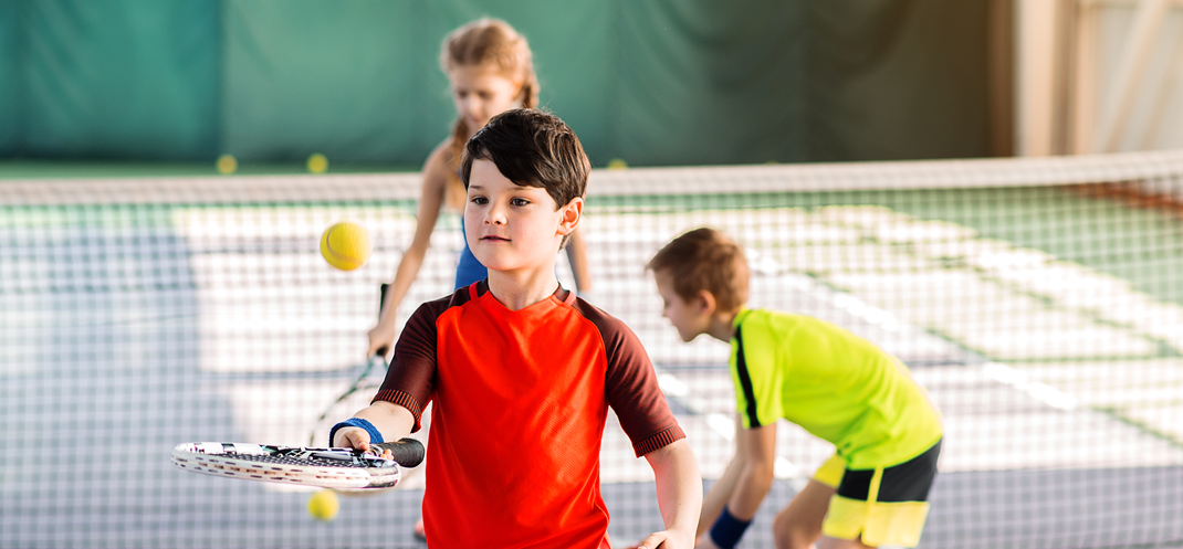 Kinder spielen Tennis